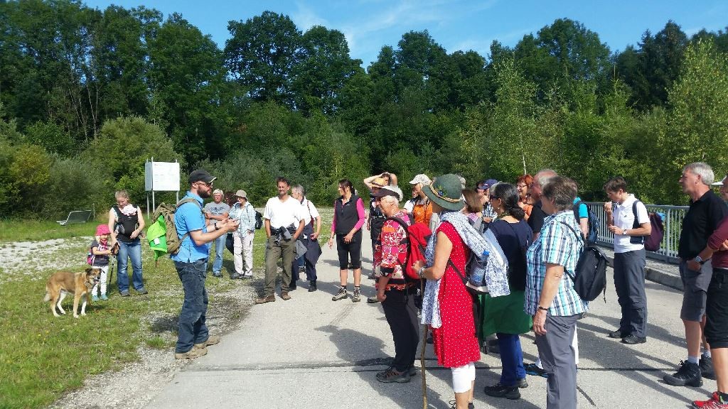 Foto von einer Exkursion an den Lech, die Teilnehmer hören Stephan Günther zu.
