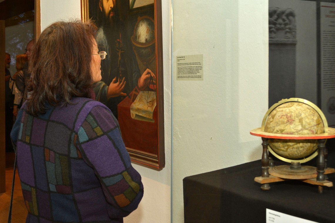 Besucherin vor einem Porträt Ignaz Köglers und einem Himmelsglobus