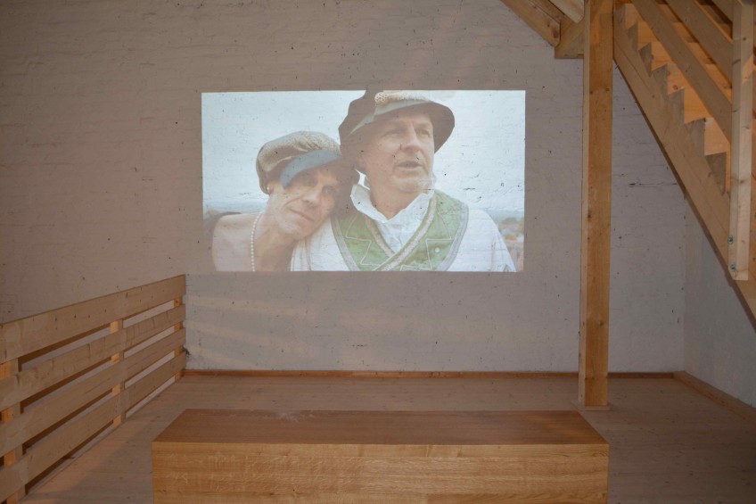 An die Wand projizierter Film mit einer Sitzbank davor