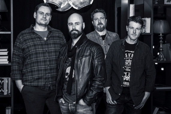 Schwarz-weiß-Foto der Band &quot;The Jan Solo Project&quot;: die vier Bandmitglieder in einem Zimmer stehend