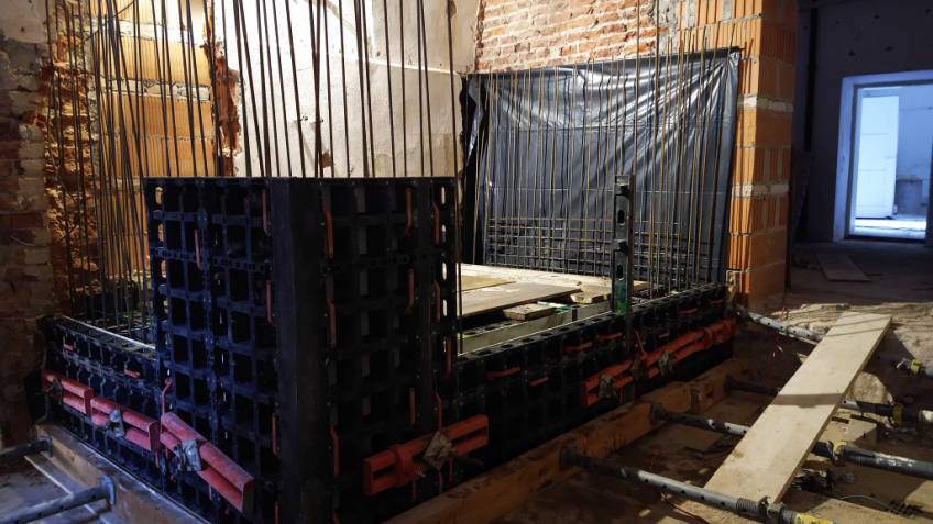 Eisenstangen und Verschalungen markieren den neuen Aufzugsraum im Keller.