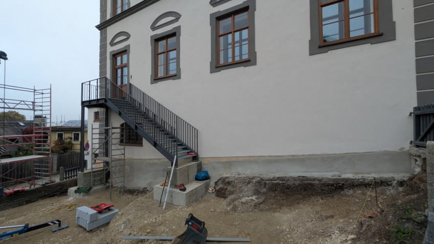 Entlang der Fassade des Museums in den Garten steht eine noch nicht vollständige Treppe.