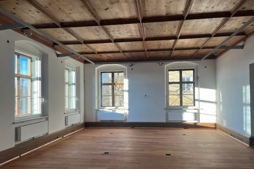 Ausstellungsraum mit wei&szlig;en W&auml;nden, gro&szlig;en Fenstern, Parkettboden und Holzdecke
